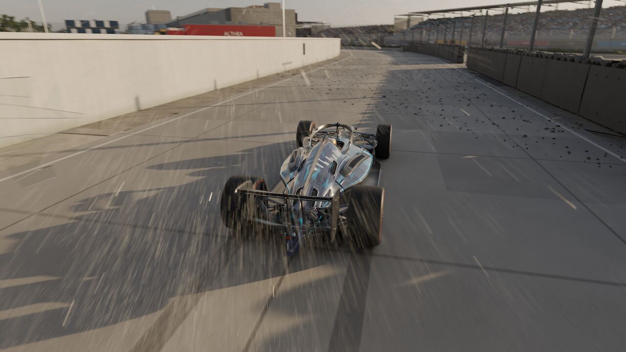 The car out on the concrete apron beyond the breached wall, glass debris skittering across the ground behind it.